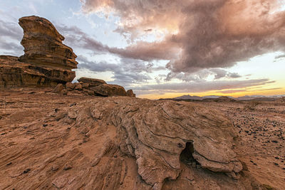 Rock formations on landscape against cloudy sky