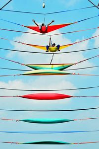 Low angle view of multi colored umbrella against blue sky