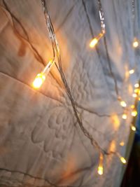 Close-up of illuminated light bulb against sky during sunset