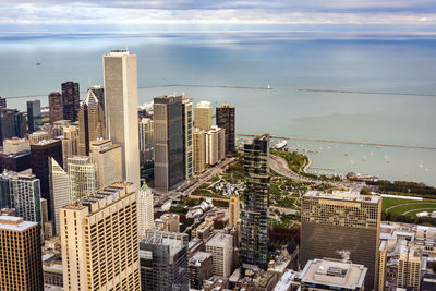 Aerial view of cityscape by sea against sky