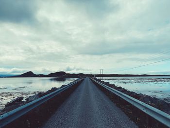 Road by bridge against sky