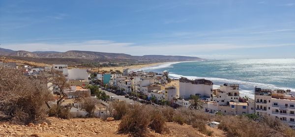 High angle view of townscape by sea against sky