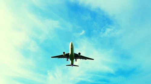 Low angle view of airplane flying against blue sky