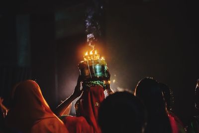 Close-up of hand holding illuminated lighting equipment at night