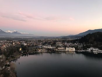 Houses by town against sky during sunset