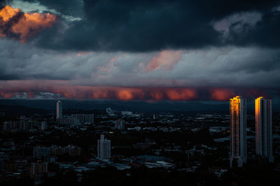 Aerial view of buildings in city at sunset