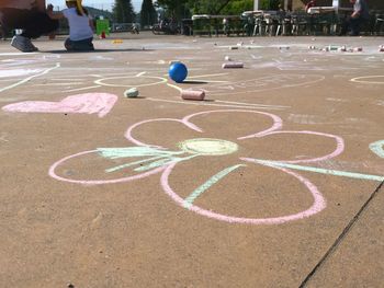 Low section of boy playing with multi colored umbrella