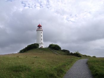 Lighthouse on landscape against sky