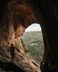 Rear view of man standing in cave