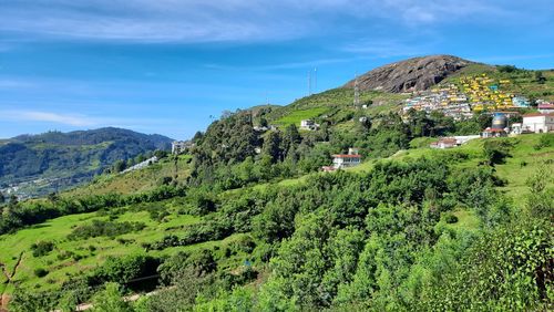 Scenic view of mountains and houses against sky