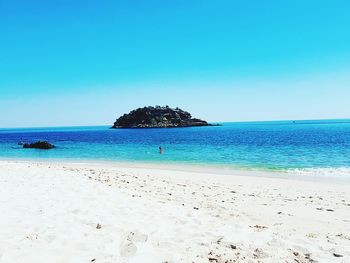 Scenic view of beach against clear blue sky