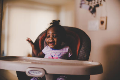 Portrait of happy girl sitting at home