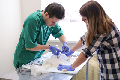 Rear view of doctor examining patient in office