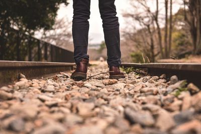 Low section of person standing on railroad track