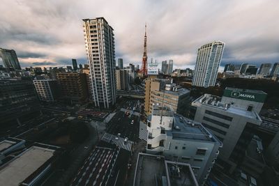 Aerial view of cityscape against cloudy sky