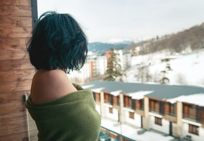 Side view of topless woman with blanket standing in balcony