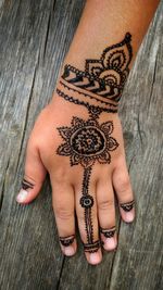 Cropped hand with henna tattoo on table
