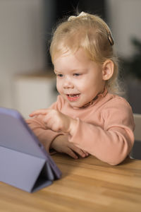 Portrait of cute baby boy sitting on table