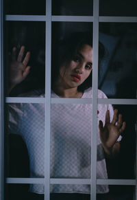 Portrait of woman looking through window