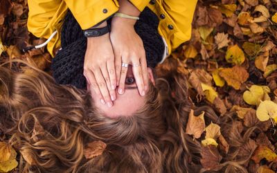 High angle view of woman standing amidst leaves during autumn