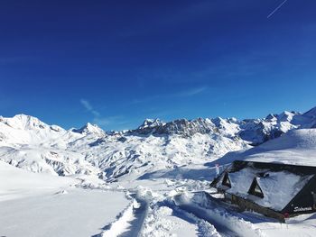 Scenic view of snowcapped mountains against blue sky