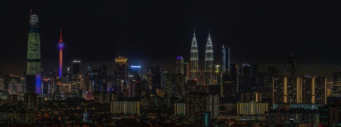 Illuminated buildings in city against sky at night