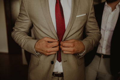 Midsection of bridegroom wearing blazer