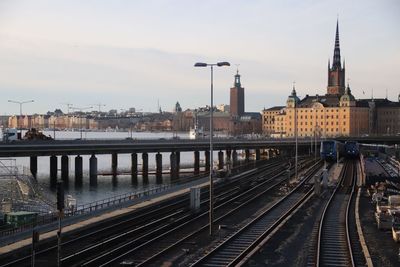 Railroad tracks in city against sky