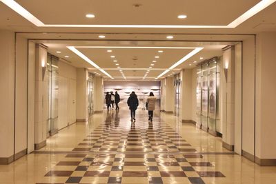 People walking in illuminated corridor