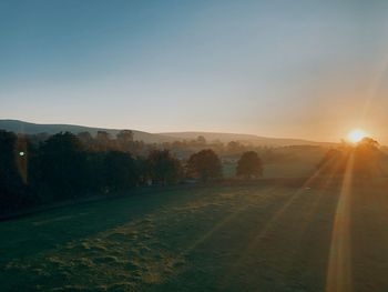 Scenic view of field against clear sky during sunset