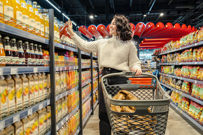 Rear view of woman standing in supermarket