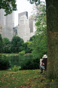 Man by tree with lake in background