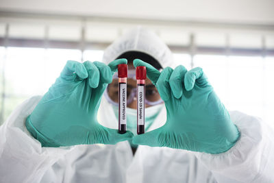 Portrait of scientist holding blood in containers