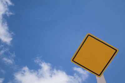 Low angle view of road sign against blue sky