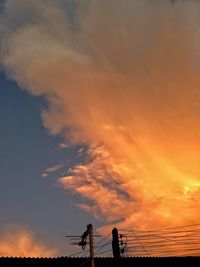 Low angle view of silhouette telephone pole against sky during sunset