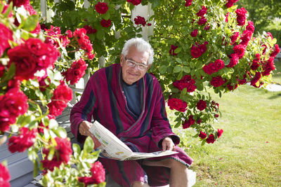 Senior man reading newspaper in garden