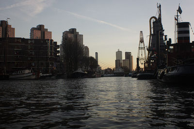River amidst buildings in city against sky
