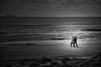 Silhouette man standing on beach against sky