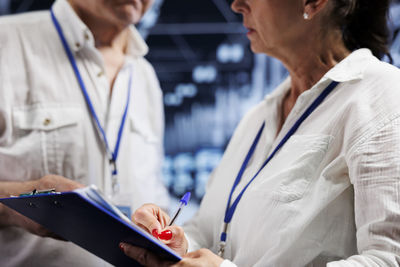 Midsection of doctor using digital tablet
