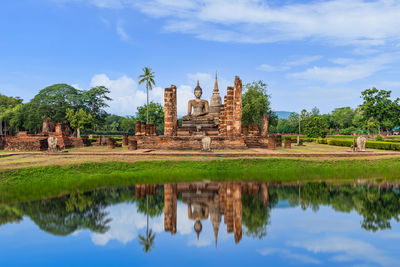 Buddha statue and pagoda at wat mahathat temple, sukhothai historical park, thailand