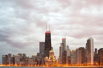 Skyscrapers in city against cloudy sky