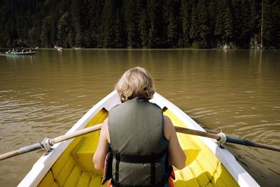 Rear view of woman boating in lake