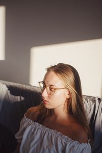 Portrait of young woman relaxing on sofa at home