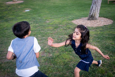 High angle view of siblings playing on field