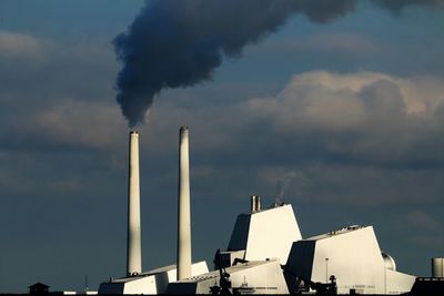 Smoke emitting from chimney against sky. poweplant in copenhagen on a windless morning.