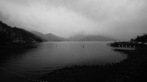 Scenic view of lake by mountains against sky