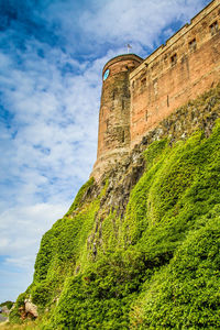 Low angle view of fort against cloudy sky