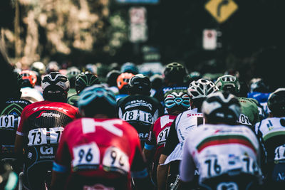 Rear view of people cycling on road