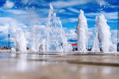 Panoramic view of sea waves splashing on shore against sky