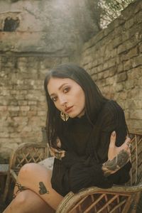 Portrait of young woman relaxing on wooden seat